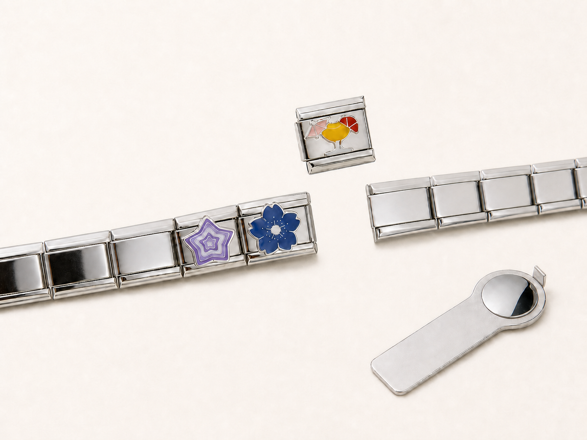 Een charm zweeft boven een open plek in een zilverkleurige linkarmband.